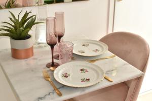 een tafel met twee borden en glazen erop bij Studio les 2 fées - Jacuzzi et Décoration Enchantée in Montfort-sur-Meu
