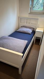 Bett mit blauer Matratze und Fenster in der Unterkunft Haus Check-In in Gütersloh