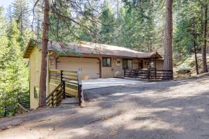 una casa con un garaje en el bosque en California Getaway with Deck and Lake Access, en Twain Harte
