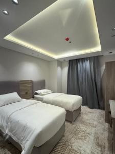 a bedroom with two beds and a ceiling at قمم بارك النماص 8 Qimam Park Hotel in Al Namas