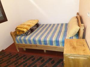 ein Bett mit einer Decke darüber in einem Zimmer in der Unterkunft Guest House Imdoukal in Aït Tamellil