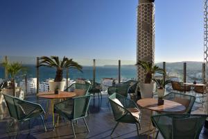 eine Terrasse mit Tischen und Stühlen und Meerblick in der Unterkunft Hilton Tanger City Center in Tangier