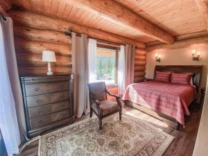 1 dormitorio en una cabaña de madera con cama y ventana en Spectacular Custom Log Cabin with Hot Tub, Epic Views, Fireplace - Moose Tracks Cabin, en Fairplay