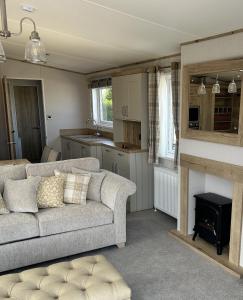 a living room with a couch and a fireplace at Sandy Toes, Padstow in Padstow