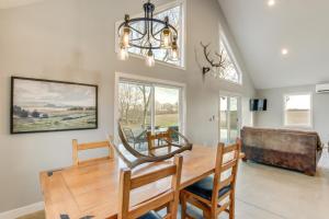 a dining room with a wooden table and a chandelier at Modern Oskaloosa Cabin with 2 Acres and On-Site Trails in Oskaloosa