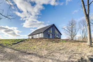 a barn on top of a hill with trees at Modern Oskaloosa Cabin with 2 Acres and On-Site Trails in Oskaloosa
