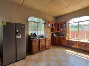 cocina con nevera de acero inoxidable y 2 ventanas en Habitacion cerca del lago, en Flores