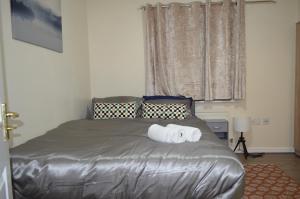 een slaapkamer met een bed met een handdoek erop bij Nice and Cosy Flat in London/Ilford/Barking, United Kingdom in Barking