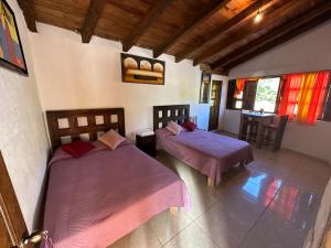 a bedroom with two beds and a table in it at Hotel del Pozo in San Sebastián del Oeste