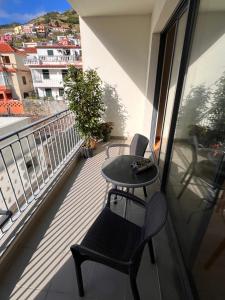 balcón con mesa y sillas en Apartment Machico near the beach, en Machico