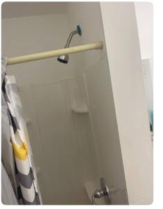 a shower door in a bathroom with a shower curtain at Home away from home in Laurelton