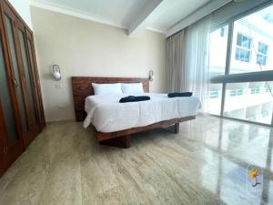 a bedroom with a large bed and a large window at Suites Presidencial Boca chica in Cuevas