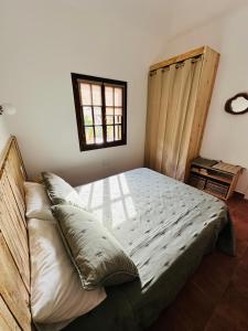 a bedroom with a large bed with a window at Casa La Pepita in Caleta De Fuste