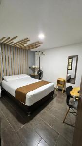 a bedroom with a large bed and a desk at Rivière Boutique Hotel in Medellín