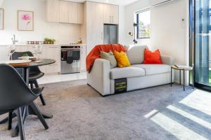 uma sala de estar com um sofá branco com almofadas coloridas em 1 Bedroom Gem with Hagley Park at your doorstep em Christchurch