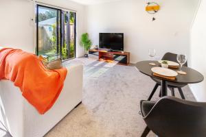 ein Wohnzimmer mit einem Tisch und einem TV in der Unterkunft 1 Bedroom Gem with Hagley Park at your doorstep in Christchurch