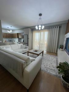 een woonkamer met een bank en een tafel bij Garden Building Luxury Apartment in Tirana