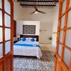 a bedroom with a bed and a ceiling fan at CASA XTABENTUN in Mérida