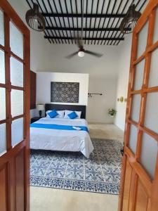 a bedroom with a bed and a ceiling fan at CASA XTABENTUN in Mérida