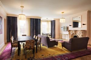 salon ze stołem, krzesłami i kominkiem w obiekcie The Hotel Chelsea w Nowym Jorku