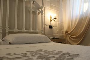 una camera con un letto bianco e un muro in pietra di Masseria Tolla a Ostuni