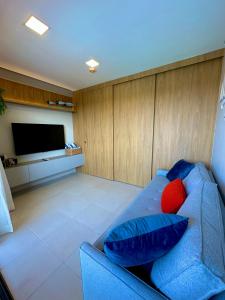 un soggiorno con divano blu e TV a schermo piatto di Flat Eco Resort Praia Dos Carneiros a Praia dos Carneiros