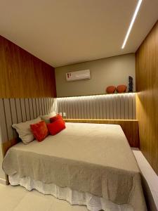 a bedroom with a large bed with red pillows at Flat Eco Resort Praia Dos Carneiros in Praia dos Carneiros