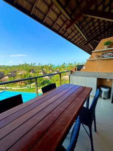 un tavolo in legno sul balcone di una casa di Flat Eco Resort Praia Dos Carneiros a Praia dos Carneiros