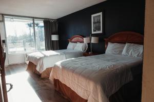 a bedroom with two beds and a window at Reidsville Inn & Suites in Reidsville