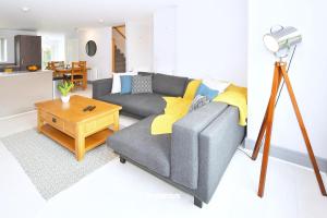 salon z szarą kanapą i stołem w obiekcie Kiln Side by Truestays - 3 Bedroom House w mieście Etruria