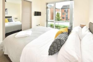 a bedroom with a white bed and a window at Kiln Side by Truestays - 3 Bedroom House in Etruria