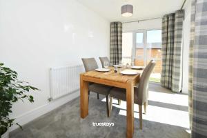 a dining room with a wooden table and chairs at Regal House by True Stays - 3 Bedroom House in Stoke-on-Trent in Stoke on Trent