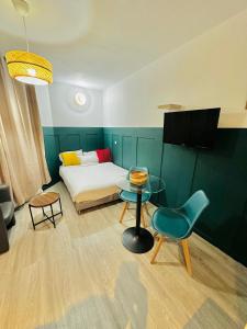 a room with a bed and a table and a chair at BtoBed - Location Professionnelle - 2 Studios Confort - Proche Parc des Expos et Stade de France in Le Bourget