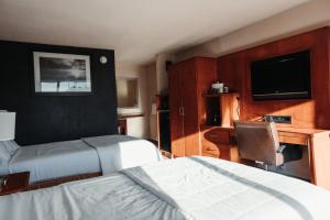 a hotel room with two beds and a television at Reidsville Inn & Suites in Reidsville