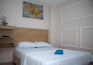 a bedroom with a bed with a blue towel on it at Hotel Horizon In in Santa Marta