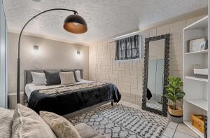 1 dormitorio con cama, espejo y sofá en The Bohemian en Red Deer