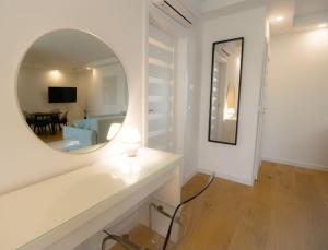 Ein weißes Zimmer mit einem Spiegel und einem Wohnzimmer. in der Unterkunft Charming Apartment in Heart of Vienna JOS 20 in Wien