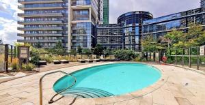 a swimming pool in a city with tall buildings at Luxury 2BR - Subway/Pool/Gym/Sauna + Free Parking in Toronto