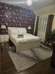 a bedroom with a bed with a floral wall at KING ROOMS BY WEMBLEY STADiUM in London