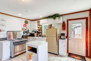 a kitchen with white cabinets and a refrigerator at Arkansas Cabin with Deck Less Than 1 Mi to Norfork Lake in Henderson +21 photos