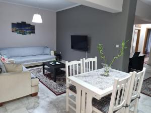 ein Wohnzimmer mit einem Tisch und einem Sofa in der Unterkunft Anthi's luxury home in Thessaloniki