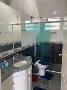 a bathroom with a toilet and a sink and a shower at Apto/garagem coberta/900m-Centro in Registro +26 photos