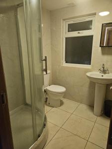 a bathroom with a shower and a toilet and a sink at KING ROOMS BY WEMBLEY STADiUM in London