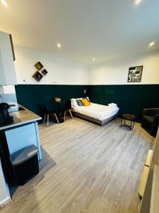 a room with a bed and a table and chairs at BtoBed - Studios Paris Le Bourget in Le Bourget