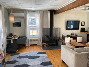 uma sala de estar com um sofá e uma televisão em Owl House - Hot Tub with rooftop terrasse em Cidade de Quebec