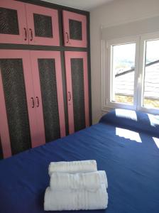 a bedroom with a blue bed with towels on it at A Travesía Dos Soños, Pedreiras in Sarria