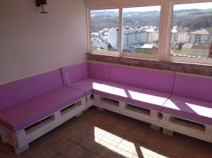 a purple bench in a room with two windows at A Travesía Dos Soños, Pedreiras in Sarria