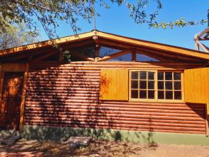 Cabaña de madera con puerta y ventana en Cabañas PLÉYADES en 