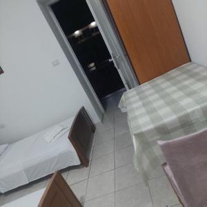 Pokój z 2 łóżkami, stołem i oknem w obiekcie Hostel Casa Mia SR w Sarandzie