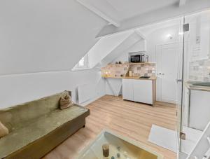 uma sala de estar com um sofá e uma cozinha em Esprit Nogentais - Vue sur Tour Eiffel em Nogent-sur-Marne